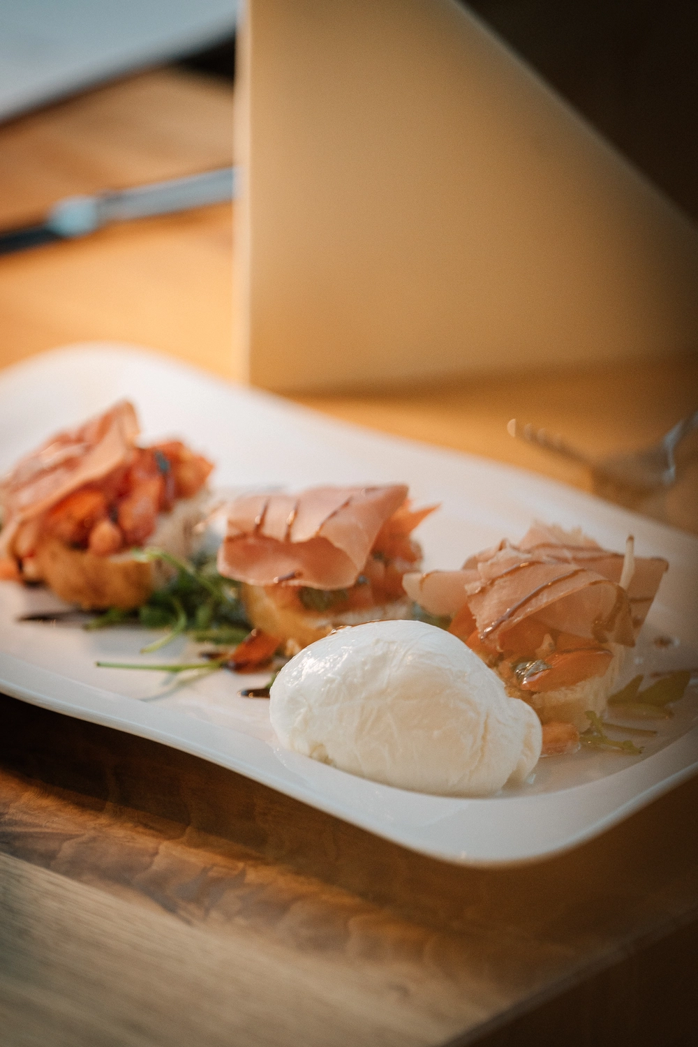 Sinn Kitchen – Restaurant – Ein Vorspeisenteller mit einem großen Klecks frischem Mozzarella und mehreren Stücken Bruschetta.