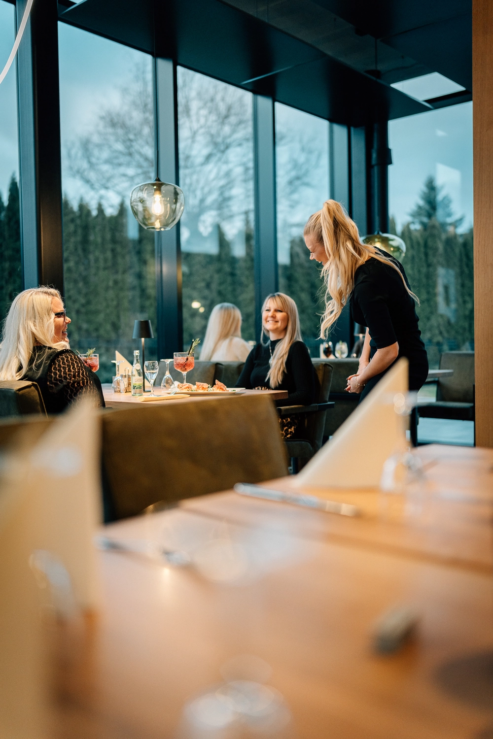 Sinn Kitchen – Restaurant – Vier junge Leute genießen ein geselliges Beisammensein in einem Restaurant oder Café am Abend.