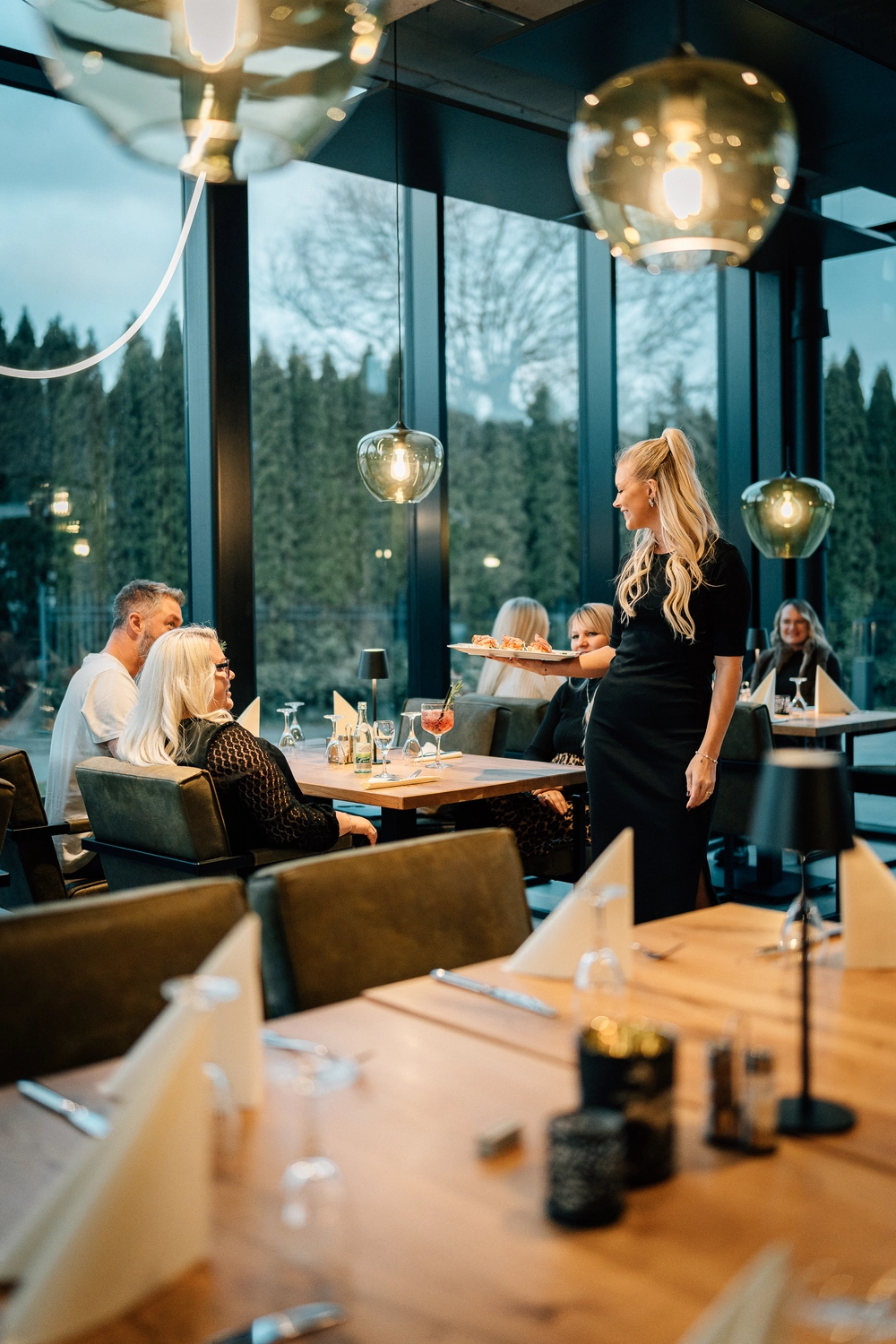 Sinn Kitchen – Restaurant – Vier junge Leute genießen ein geselliges Beisammensein in einem Restaurant oder Café am Abend.