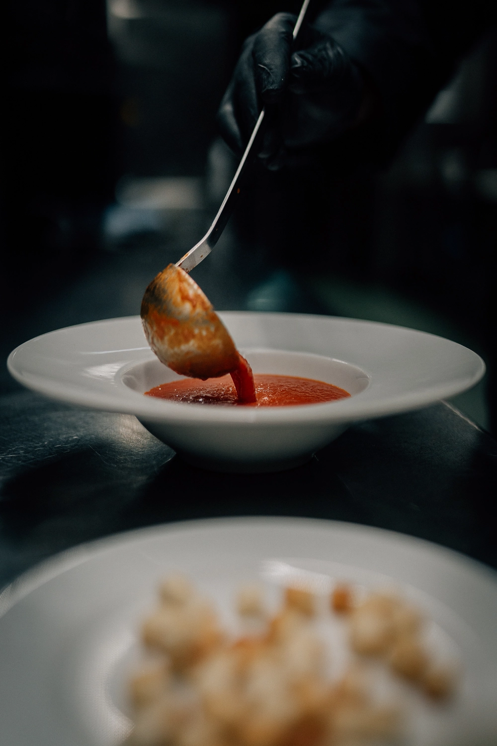 Sinn Kitchen - Restaurant - Ein Koch bereitet eine Schüssel Tomatensuppe zu.