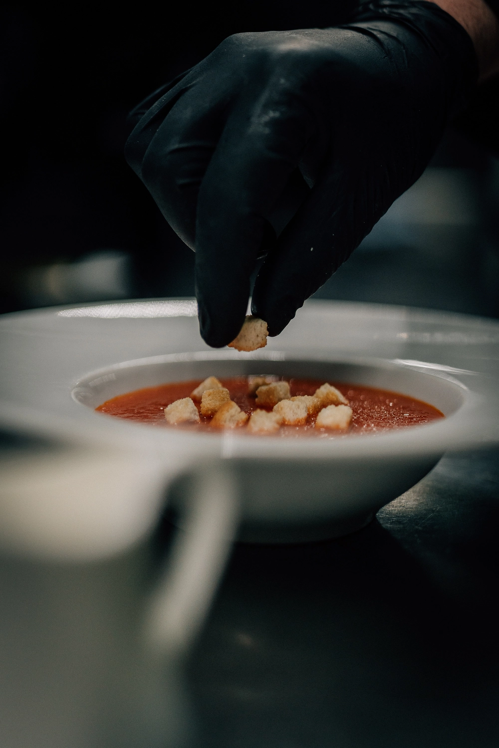 Sinn Kitchen - Restaurant - Ein Koch bereitet eine Schüssel Tomatensuppe zu.