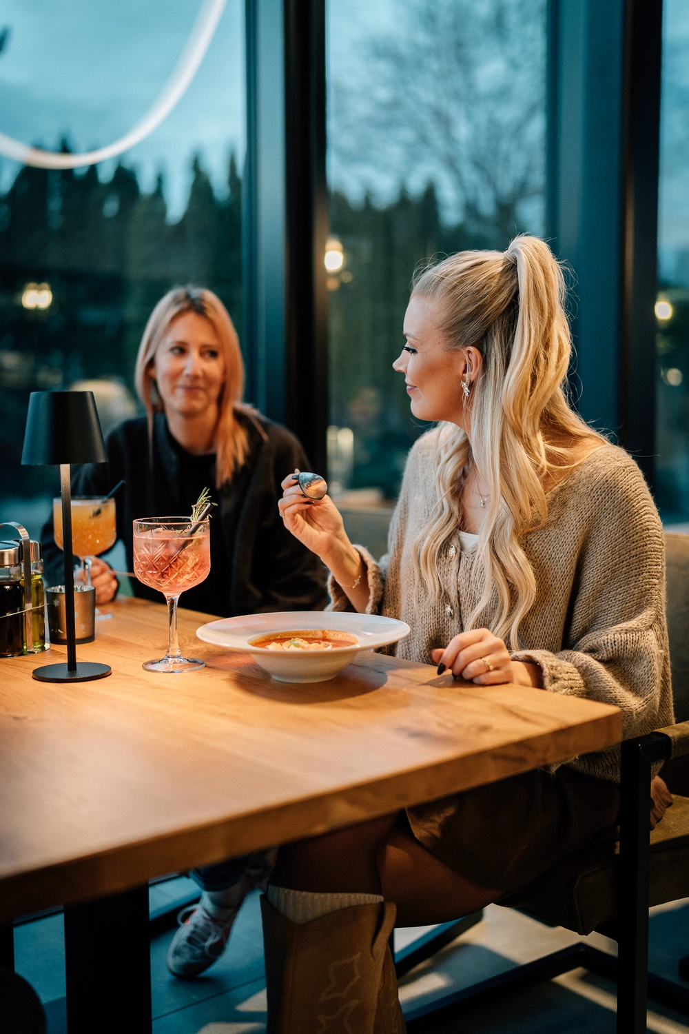 Sinn Kitchen – Restaurant – Vier junge Leute genießen ein geselliges Beisammensein in einem Restaurant oder Café am Abend.