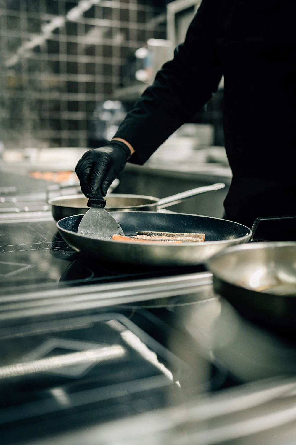 Sinn Kitchen – Restaurant – Der Koch bereitet Speisen zu.