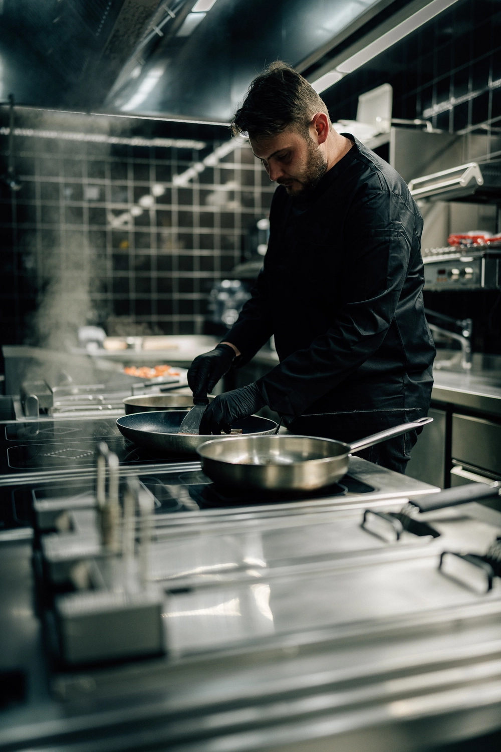 Sinn Kitchen – Restaurant – Der Koch bereitet Speisen zu.