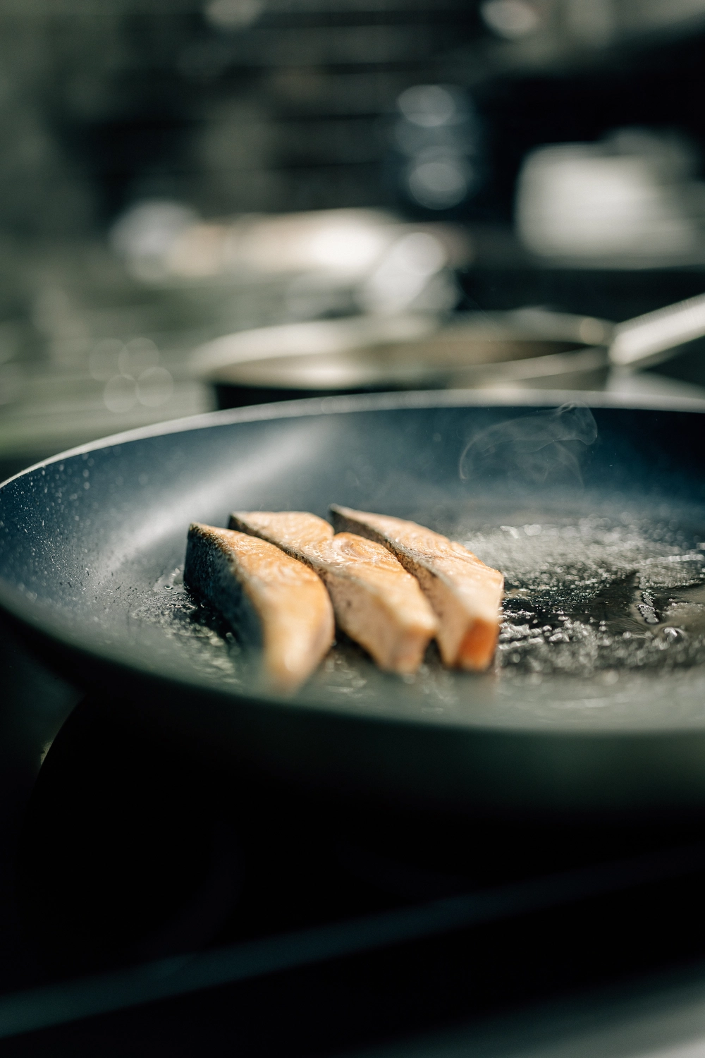 Sinn Kitchen – Restaurant – Der Koch bereitet Speisen zu.