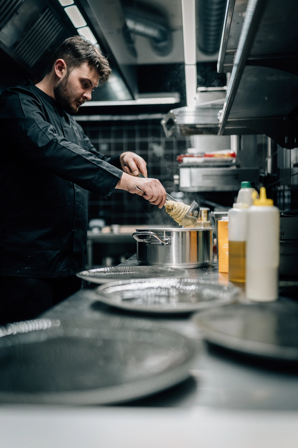 Sinn Kitchen – Restaurant – Ein Koch bereitet Bruschetta mit Prosciutto und Mozzarella zu.